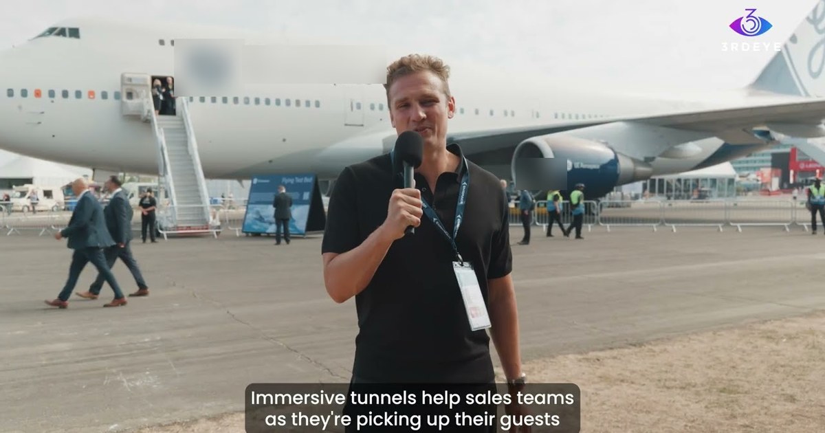 Host presenting in front of a business jet at Farnborough International Airshow, where an immersive tunnel activation welcomed senior guests